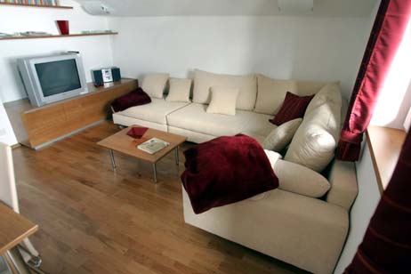 Die große Wohnzimmer-Couch, die durch Verschieben des linken Elements zum Doppelbett wird